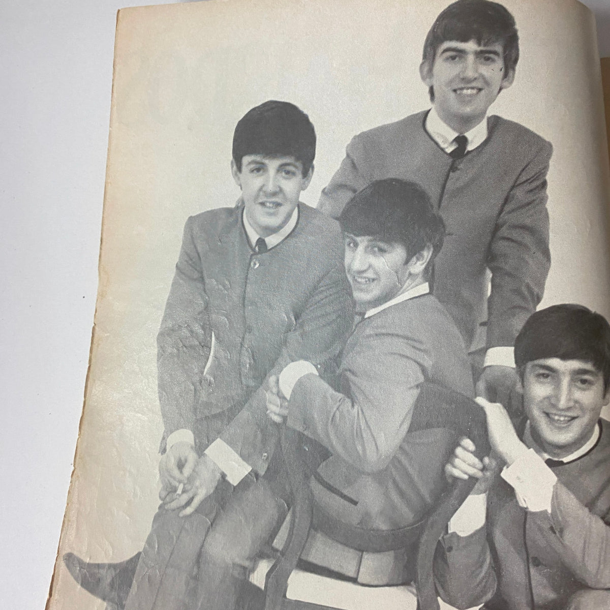 Black and white photo from '1964 Beatle Hairdos and Setting Patterns No Label' showing the Beatles seated together, showcasing their iconic hairstyles.