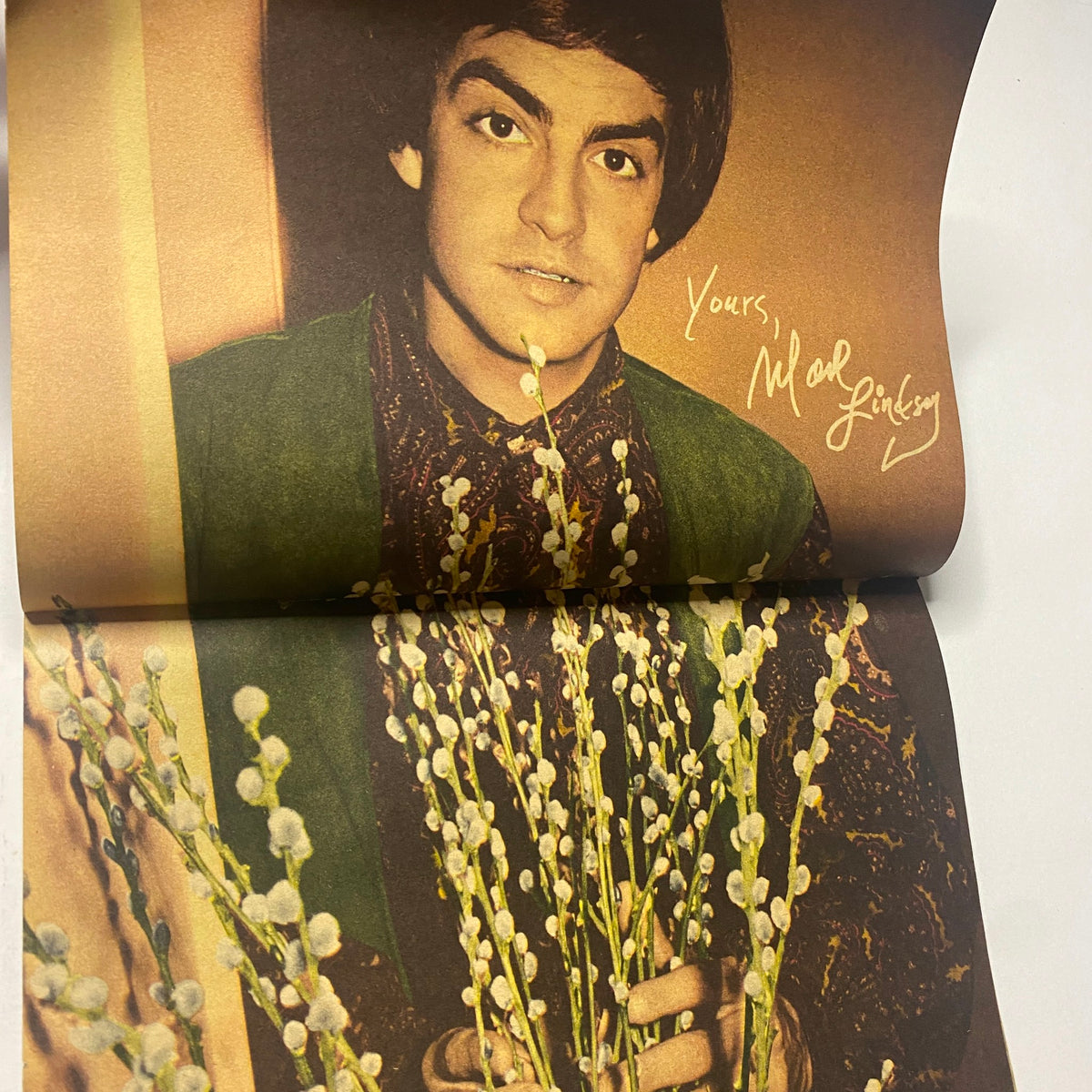 Mark Lindsay featured in 16 Magazine April 1966, holding flowers and signing the page, reflecting the essence of the 1960s pop culture.