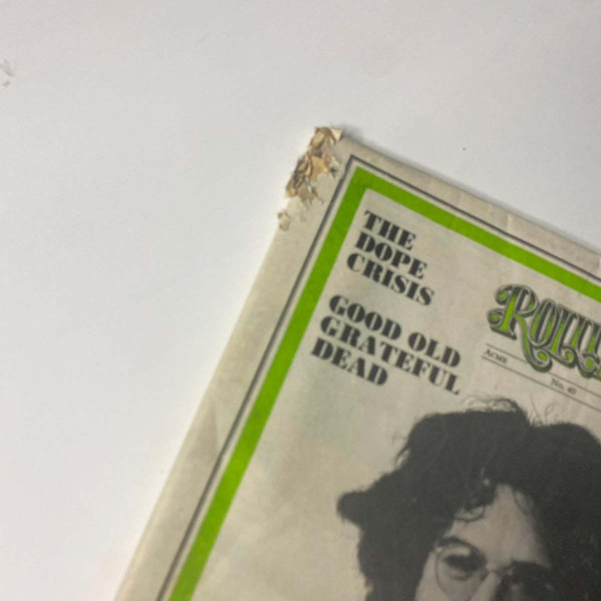 Close-up of the corner of Rolling Stone Magazine August 23, 1969 featuring Jerry Garcia on the cover, showing signs of aging with a small tear.