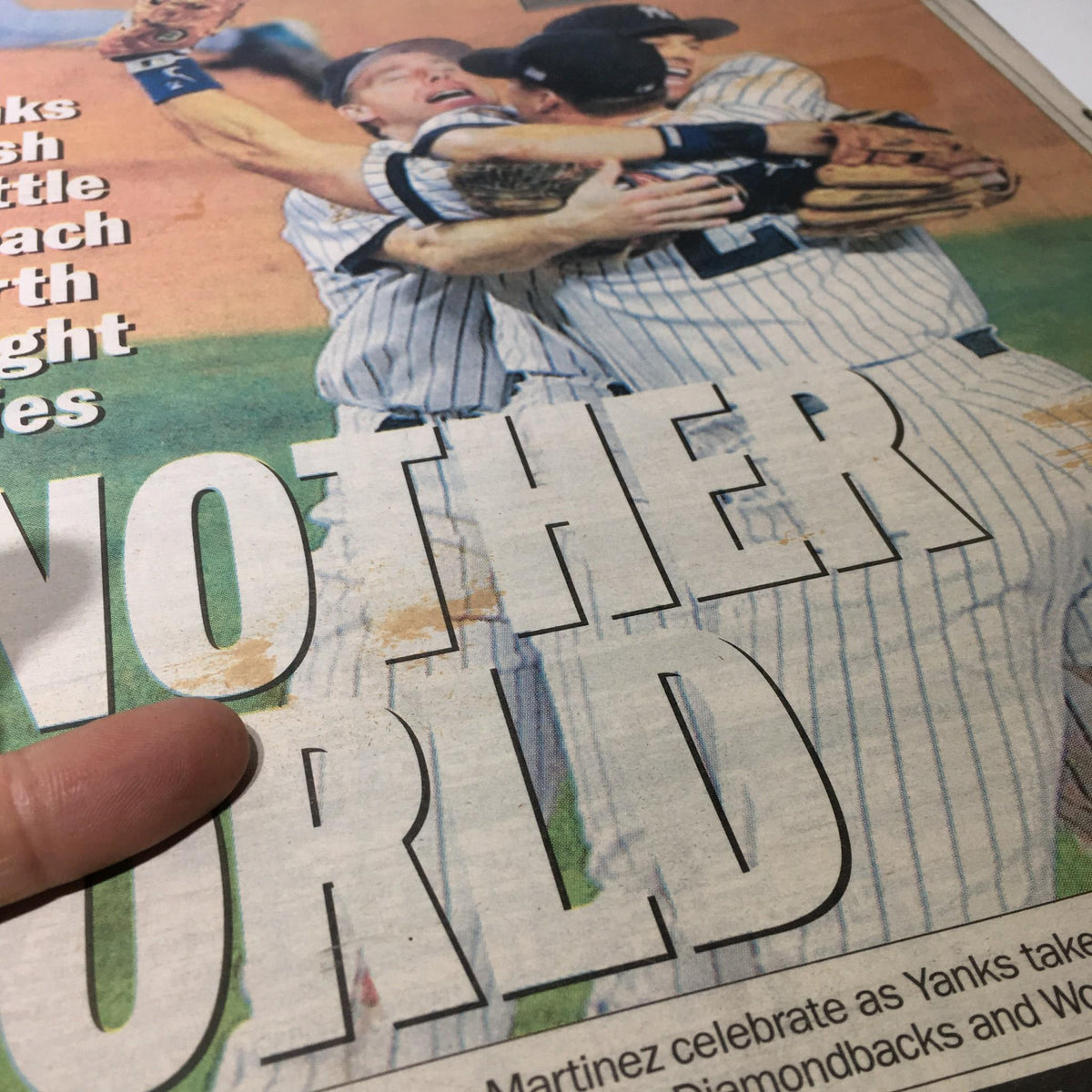 Detailed shot of the NY Daily News sports page capturing the celebration of Yankees players after winning their fourth straight pennant.