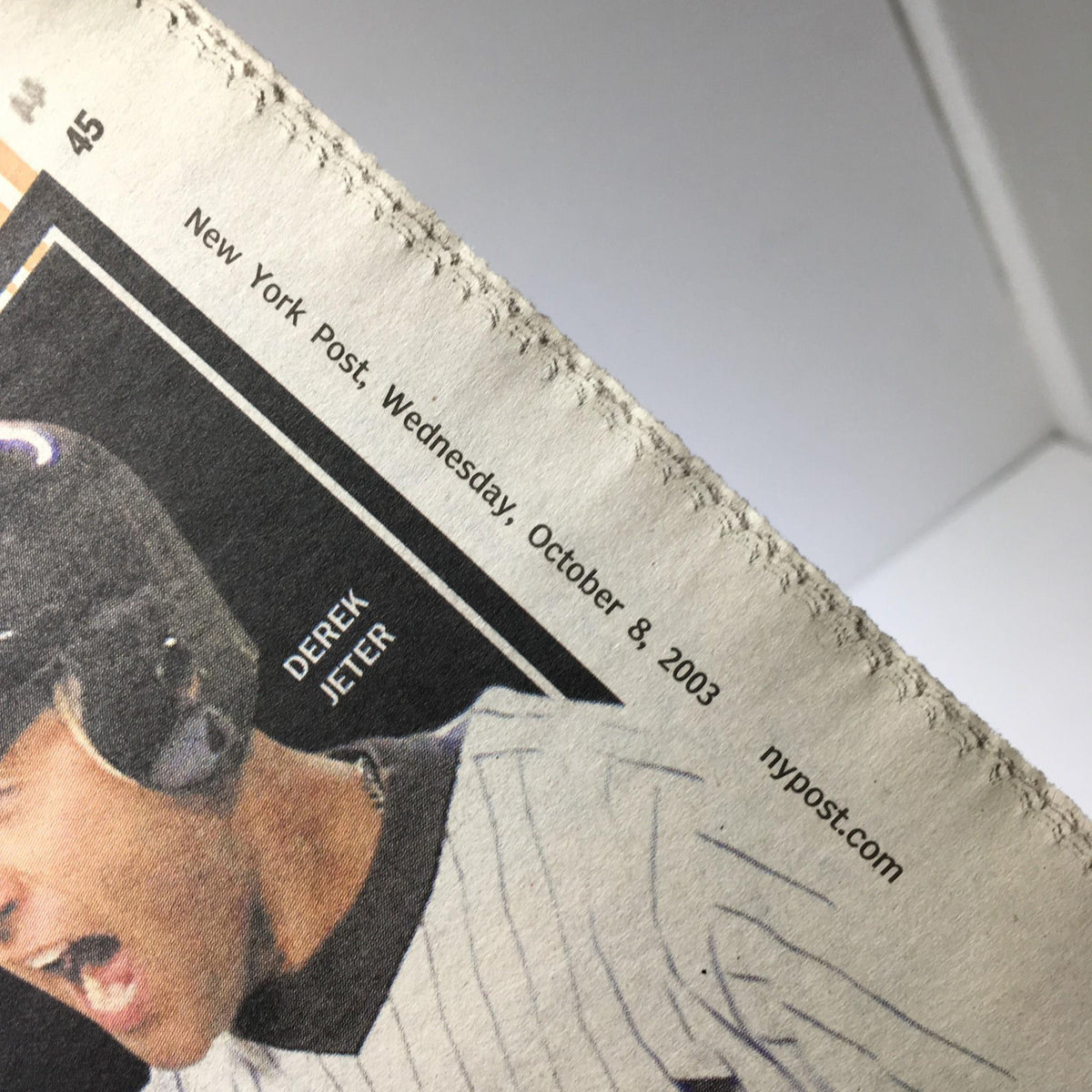 Close-up of a New York Post newspaper dated October 8, 2003, featuring a prominent image of Derek Jeter, highlighting the headline "Haunted Red Sox Brace 4 Yanks & Curse of Bambino."