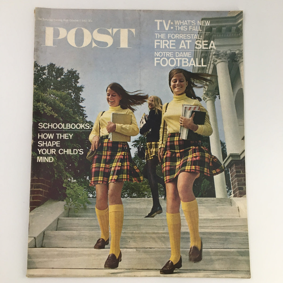 Cover of The Saturday Evening Post from October 7, 1967, featuring three schoolgirls in yellow sweaters and plaid skirts walking down the stairs, highlighting the theme of the Forrestal Fire at Sea.