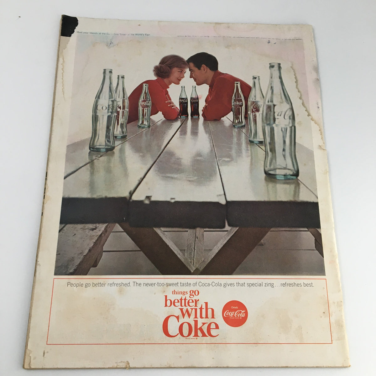 Cover of The Saturday Evening Post May 2, 1964 featuring a vintage Coca-Cola advertisement with a couple sitting at a picnic table surrounded by glass Coke bottles.