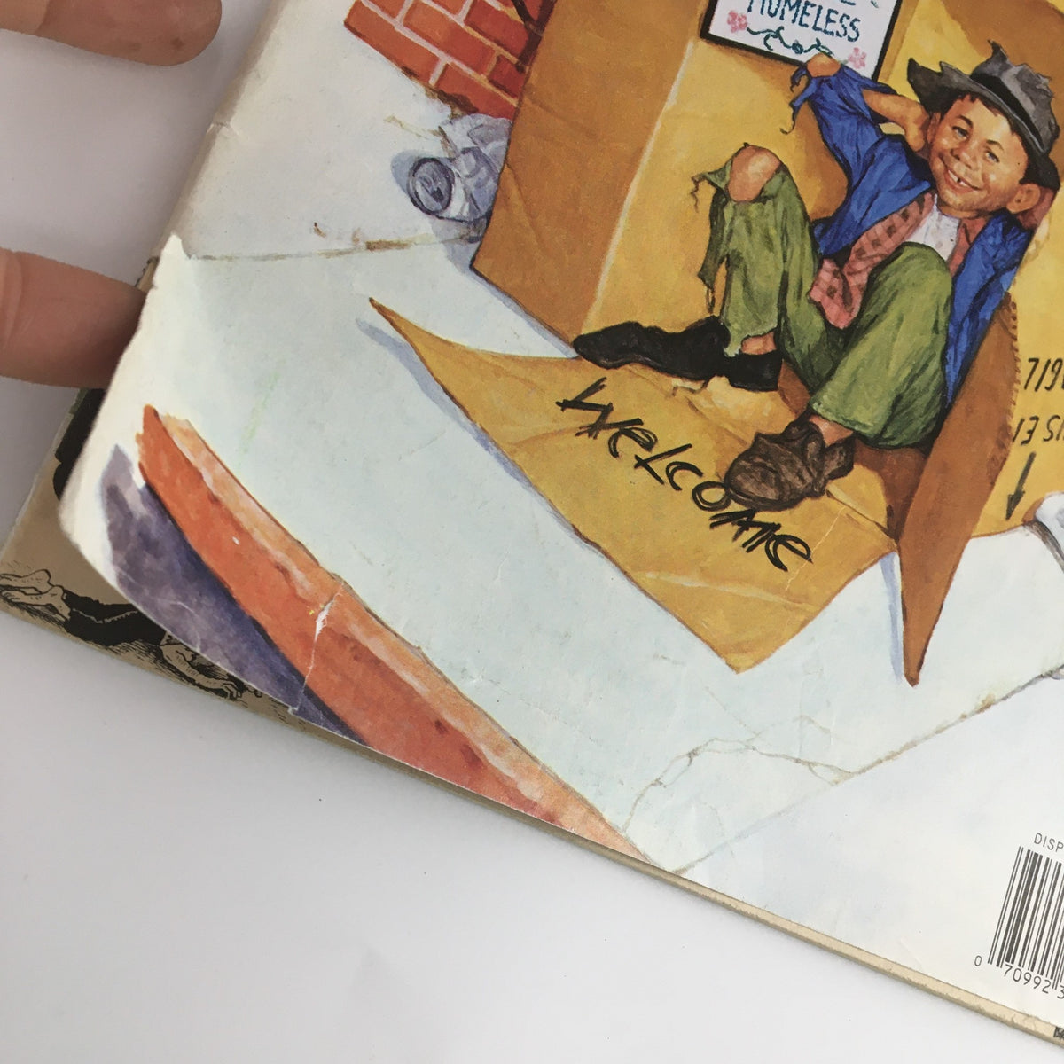 Detailed view of the Mad Magazine March April 1994 #326 Economic Recovery Issue cover showing a child sitting in a cardboard box with a welcoming sign.