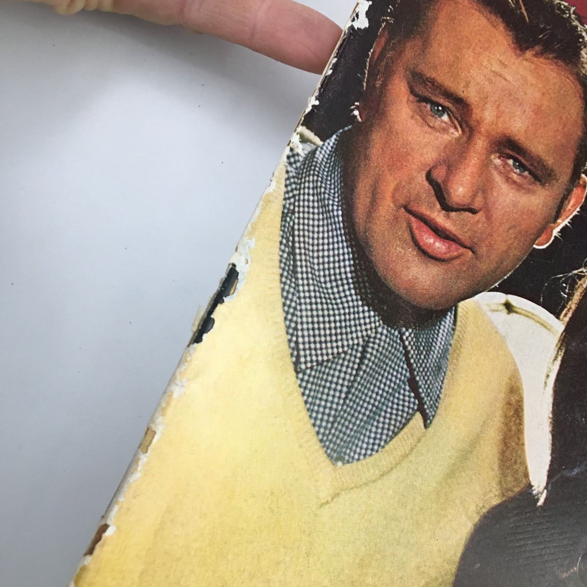 Detailed view of a worn corner of The Saturday Evening Post October 9, 1965, featuring notable actors Liz Taylor and Richard Burton.