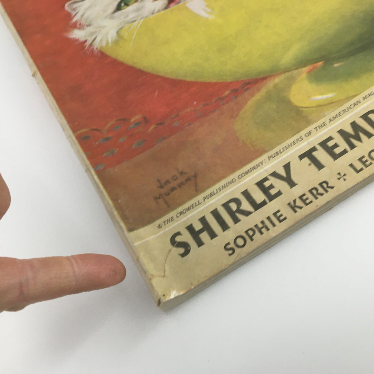 Close-up of the November 1938 Woman's Home Companion Magazine cover showcasing Shirley Temple, highlighting its edge wear and the signature of the artist, Jack Murray.