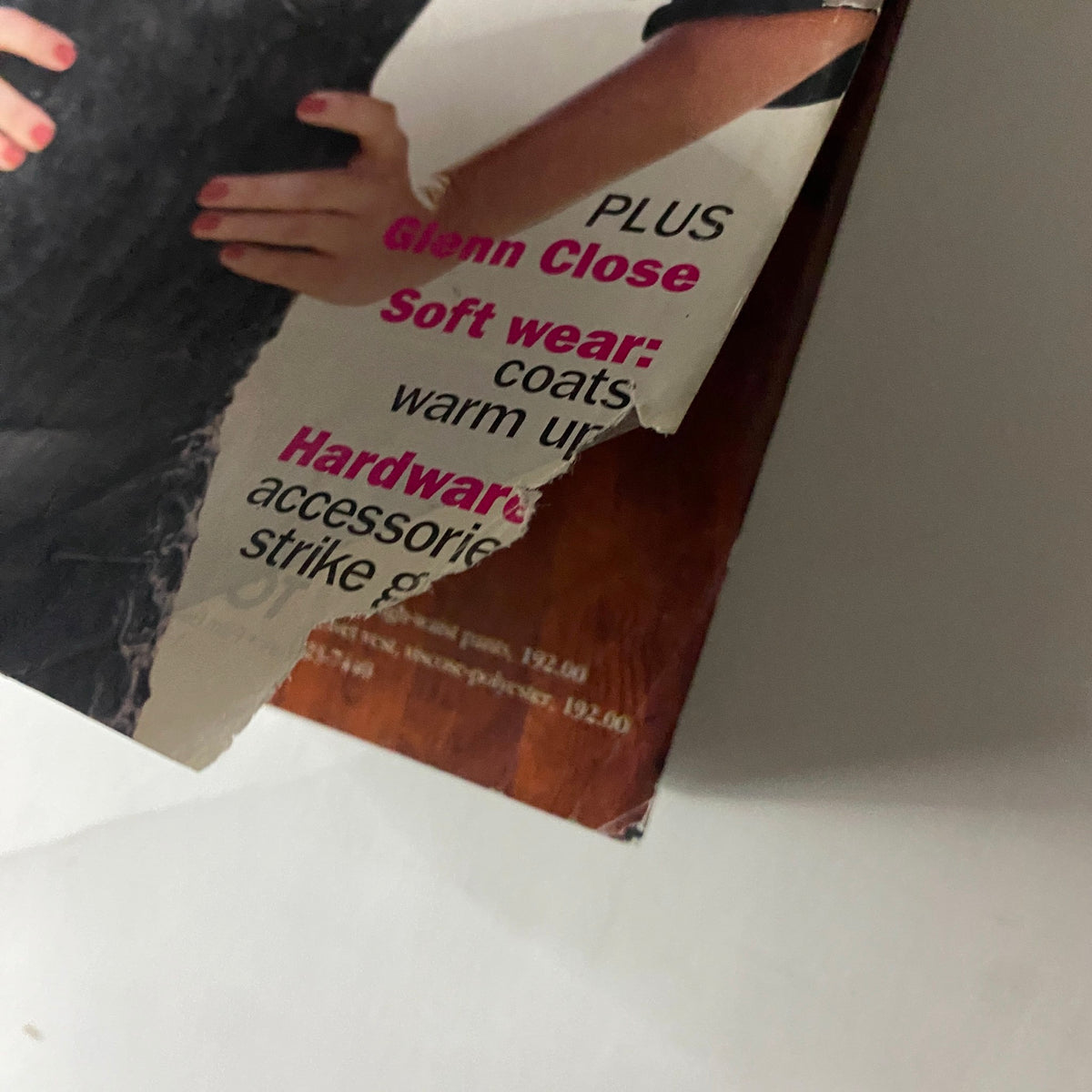 Close-up of the torn edge of Vogue Magazine November 1994 featuring Cindy Crawford on the cover, showcasing text about fashion and accessories.