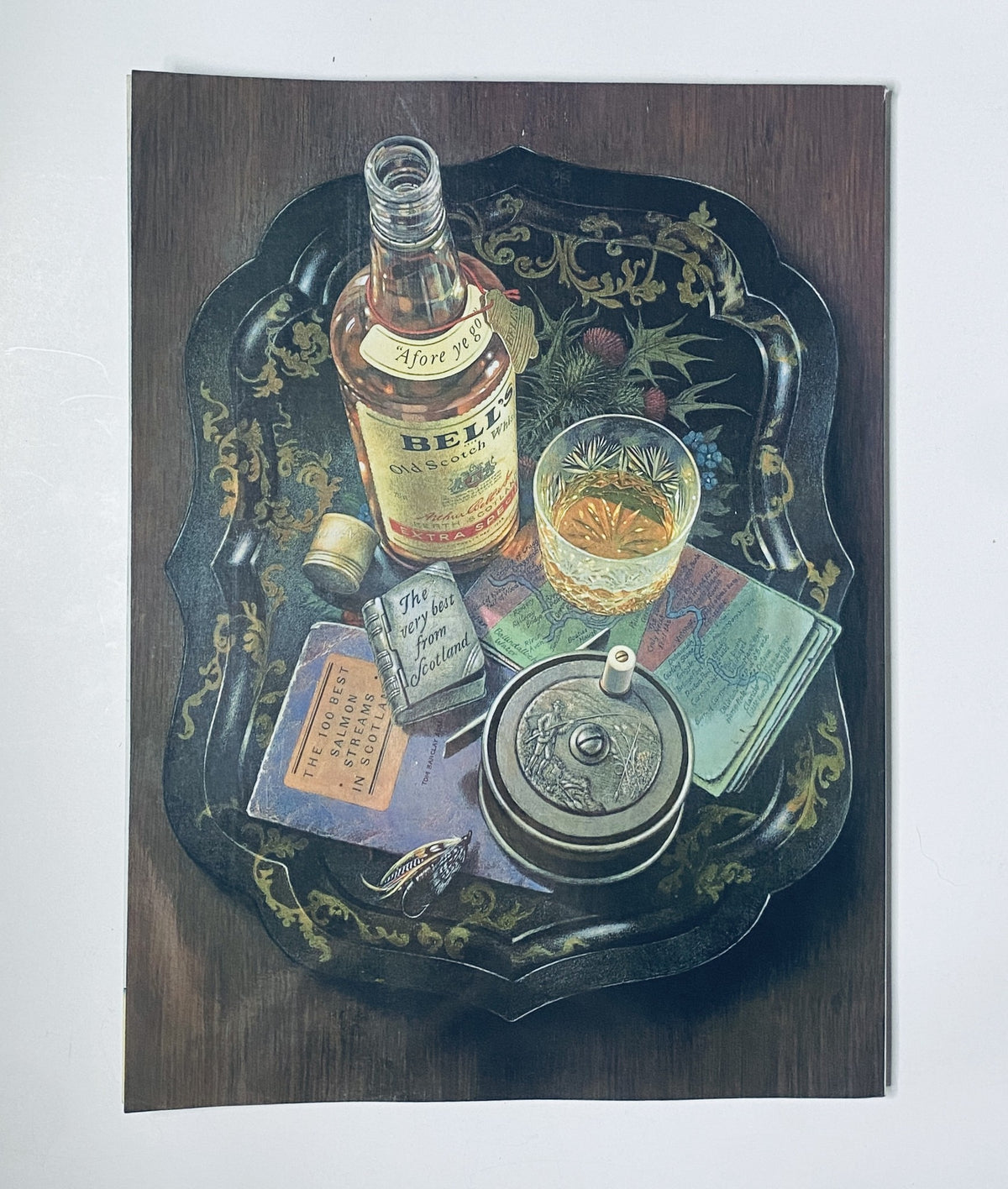 Artistic still life depicting a tray with a bottle of Belvedere, a glass of whiskey, various books, and collectibles, showcasing a vintage aesthetic.