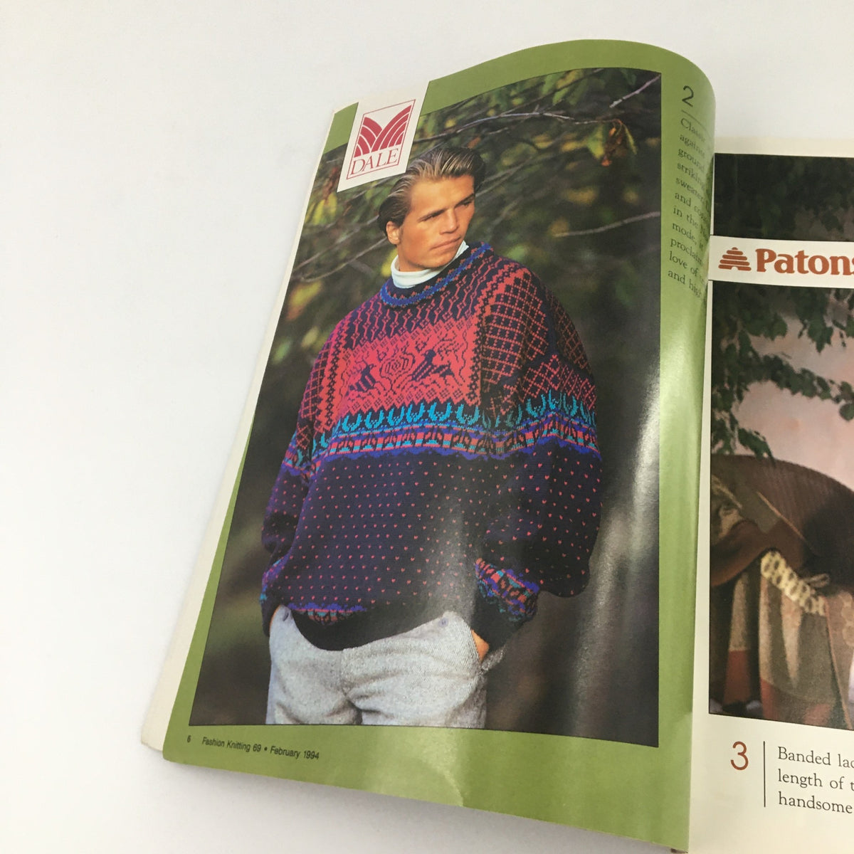Interior page from Fashion Knitting Magazine February 1994 #69 showcasing a colorful knitted sweater modeled by a man in a nature setting.