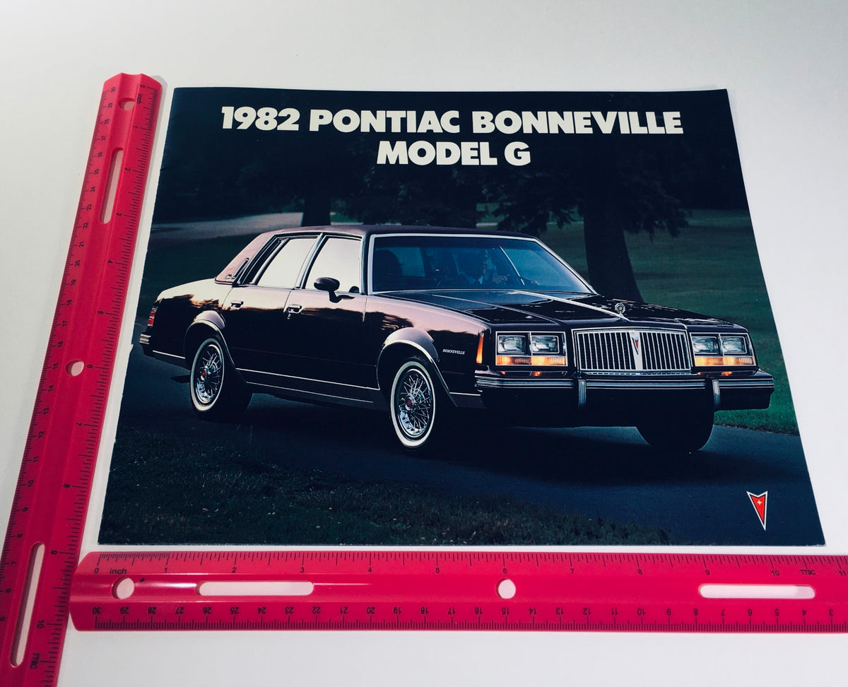 1982 Pontiac Bonneville Model G Brougham 4-Door Sedan Car Sales Brochure with a ruler for size reference, displaying the classic car's exterior.