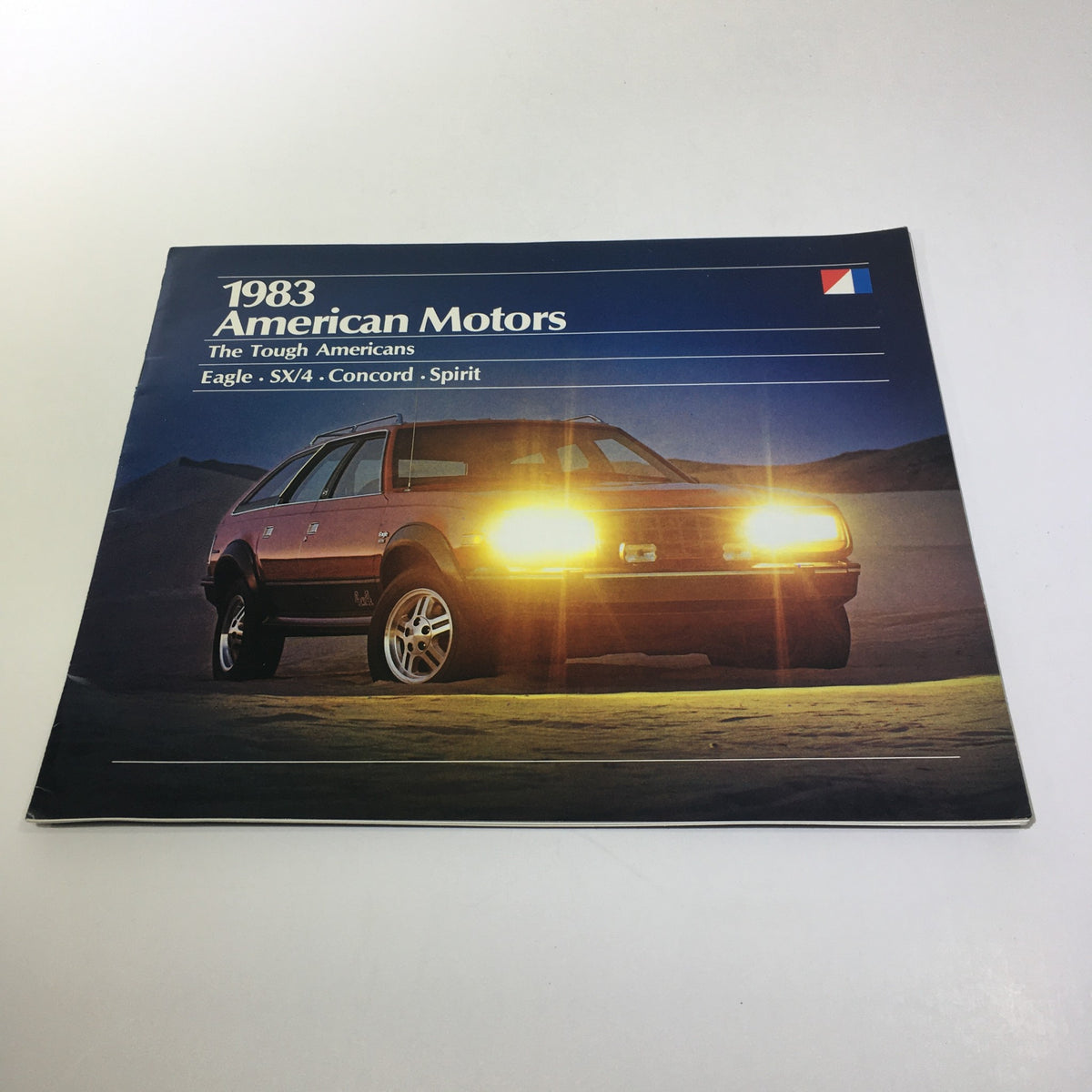 Cover of the 1983 American Motors Eagle-SX/4-Concord-Spirit 6-Cylinder 4-Speed Car Brochure showcasing a stylish vehicle with headlights on against a scenic backdrop.