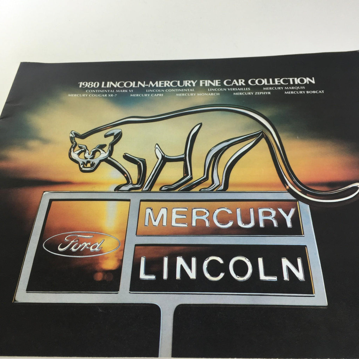 Cover of the 1980 Lincoln-Mercury Collection Lincoln Continental Town Coupe Car Sale Brochure featuring the iconic Mercury logo with a stylized cat.
