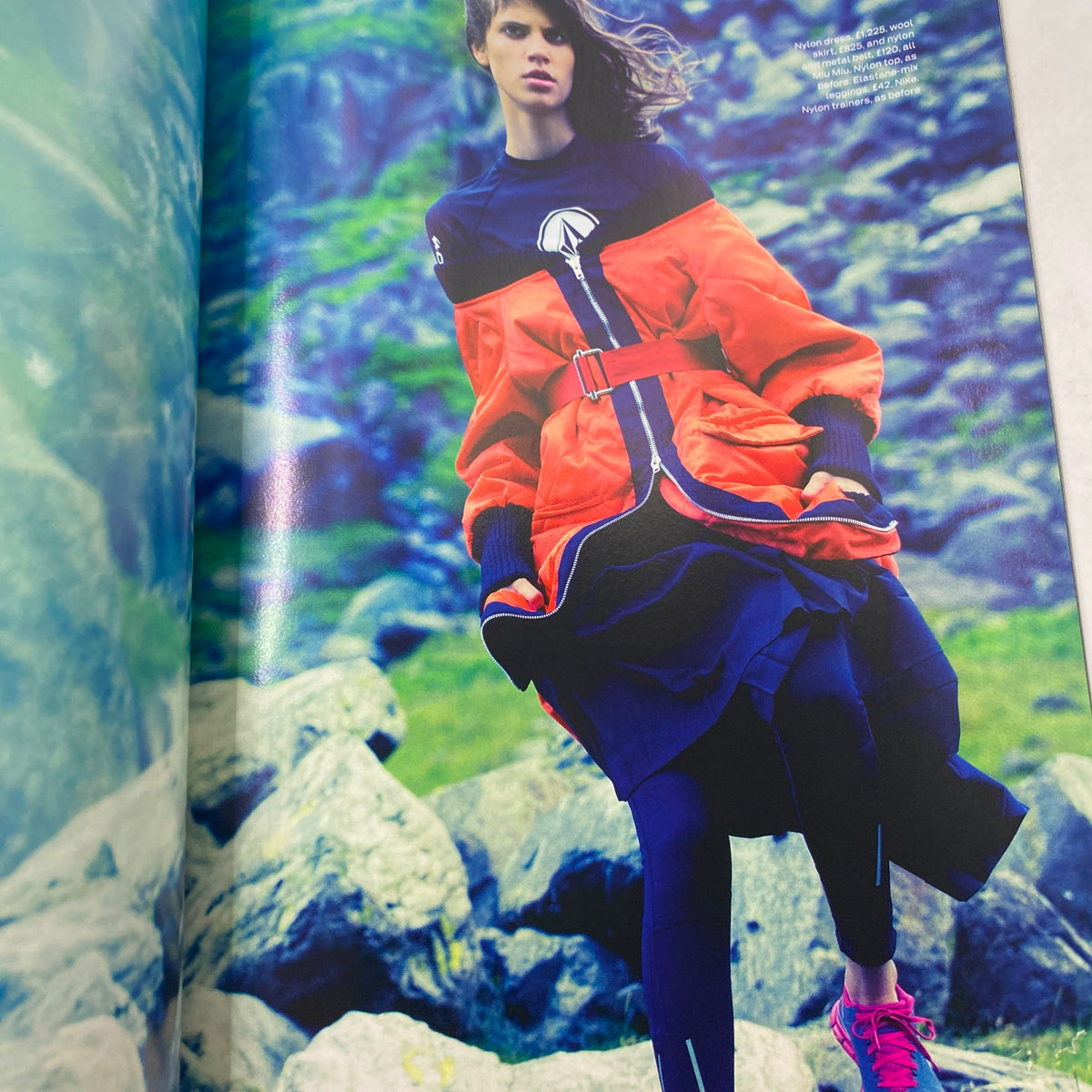 Elle UK Magazine November 2013 featuring a model in vibrant outdoor fashion, showcasing a stylish orange and black layered outfit set against a backdrop of rocky terrain.
