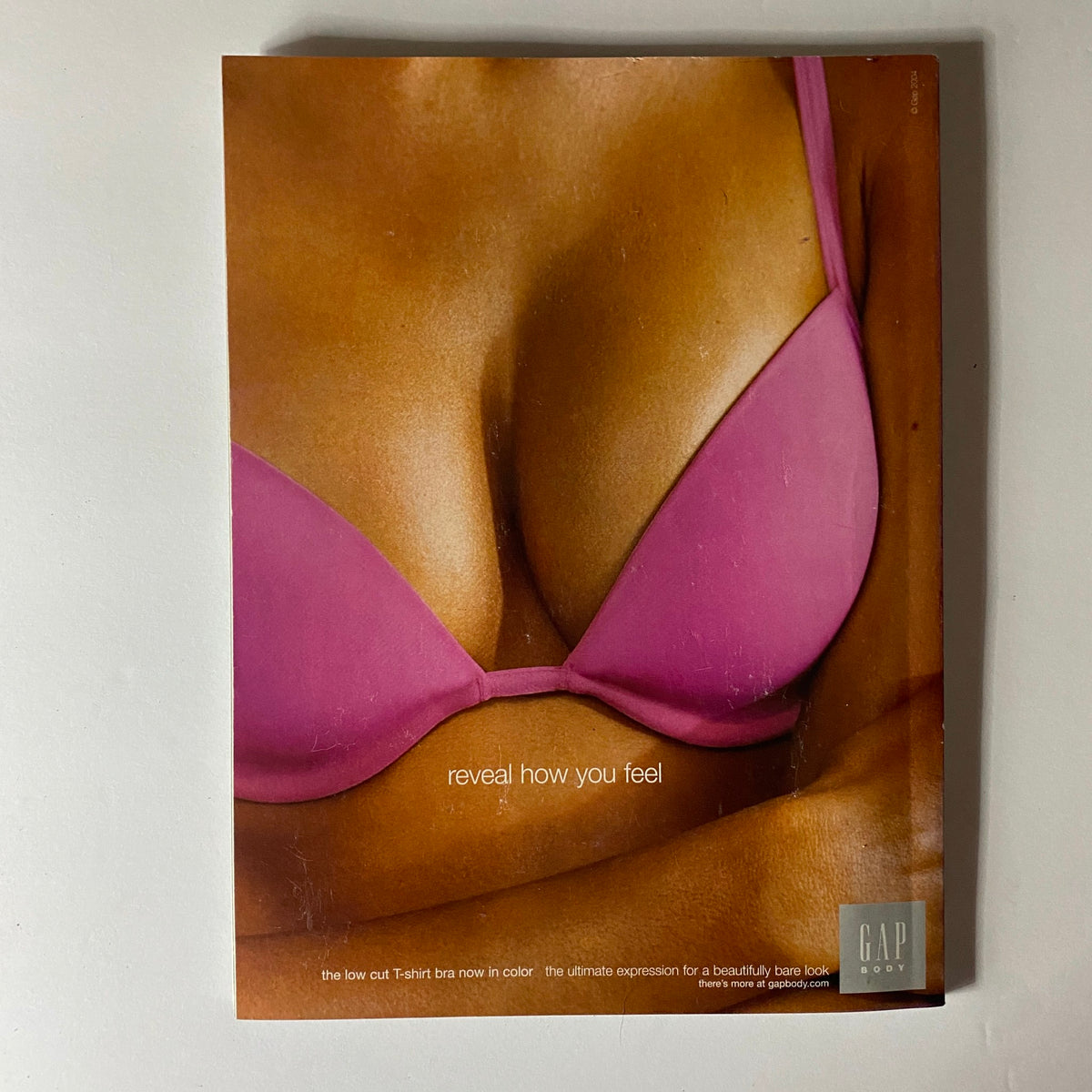 Back cover of Elle Magazine August 2004, featuring an advertisement for GAP, showcasing a pink bra with the tagline, 'reveal how you feel'.