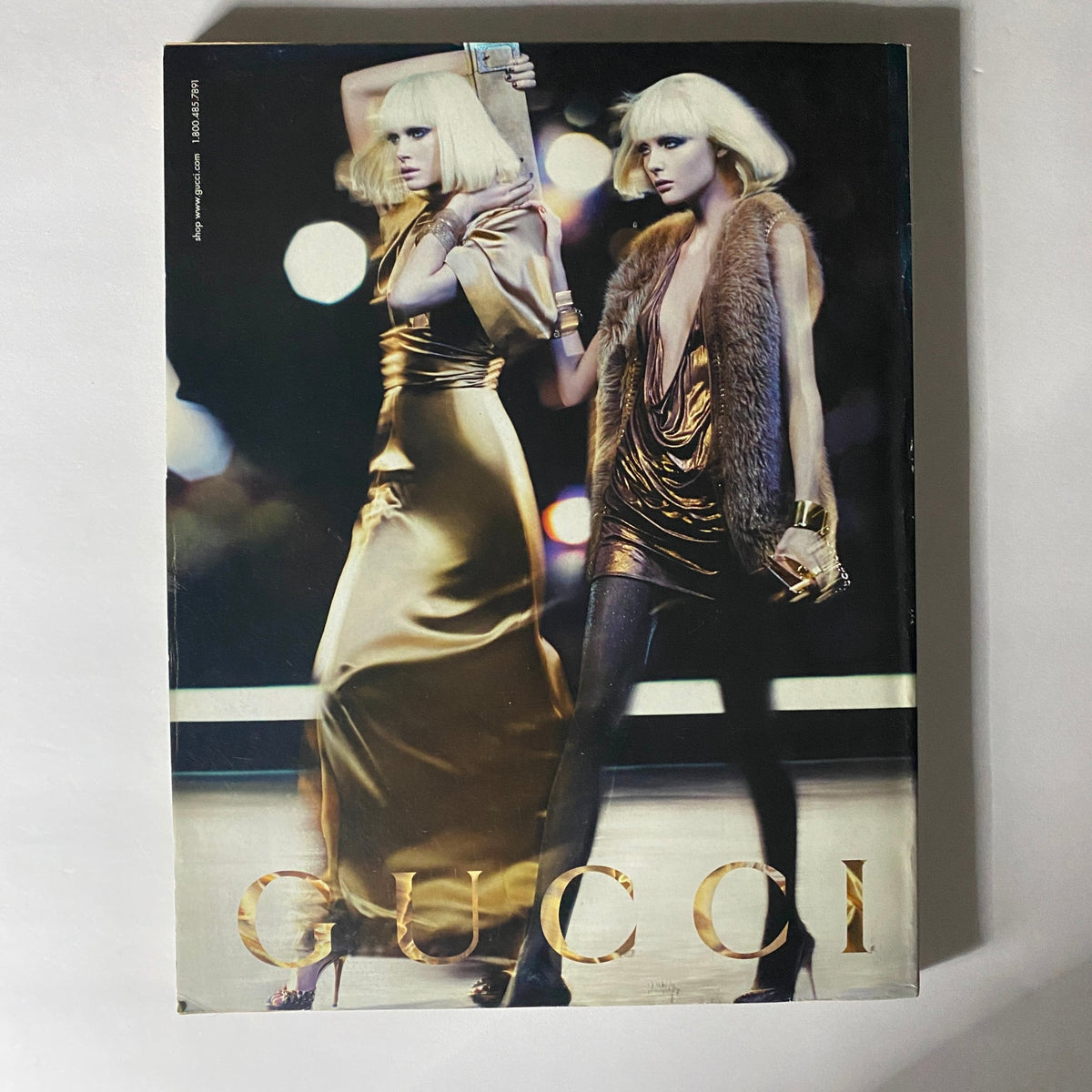 Gucci advertisement featured in W Magazine October 2006, displaying models in glamorous outfits, representing high-fashion trends of the era.