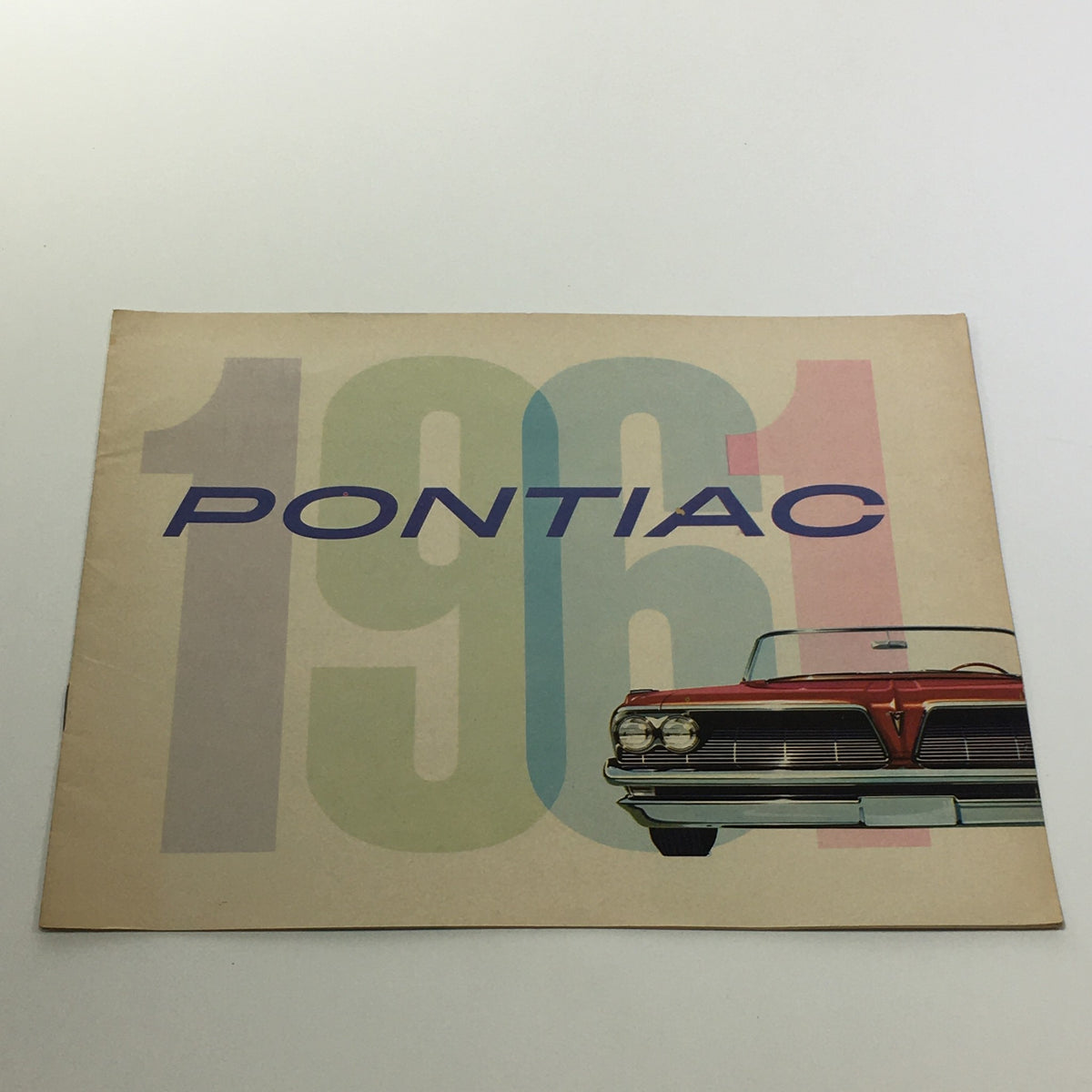 Cover of the 1961 Pontiac Trophy Economy V-8 Engine 303-Horsepower Car Sale Brochure featuring bold typography and a classic Pontiac car design.