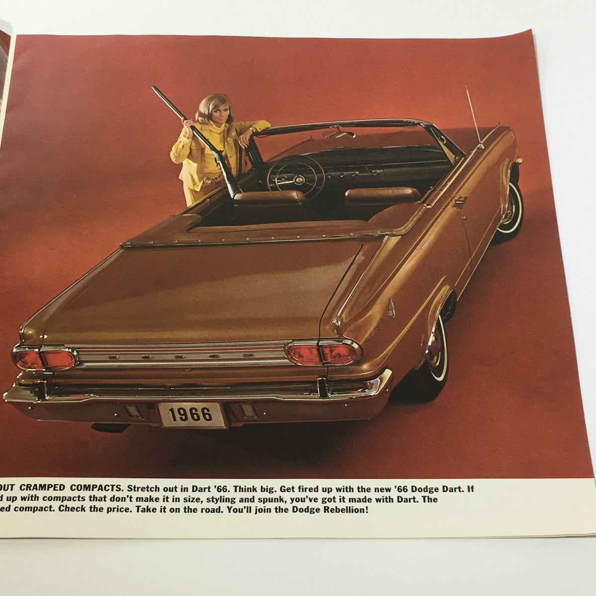 1966 Dodge Dart V-8 Engine 4-Speed Gearbox 2-Door Sedan Car Sale Brochure viewed from above, displaying a woman in a yellow outfit seated in a Dodge Dart convertible with an emphasis on its spacious interior.
