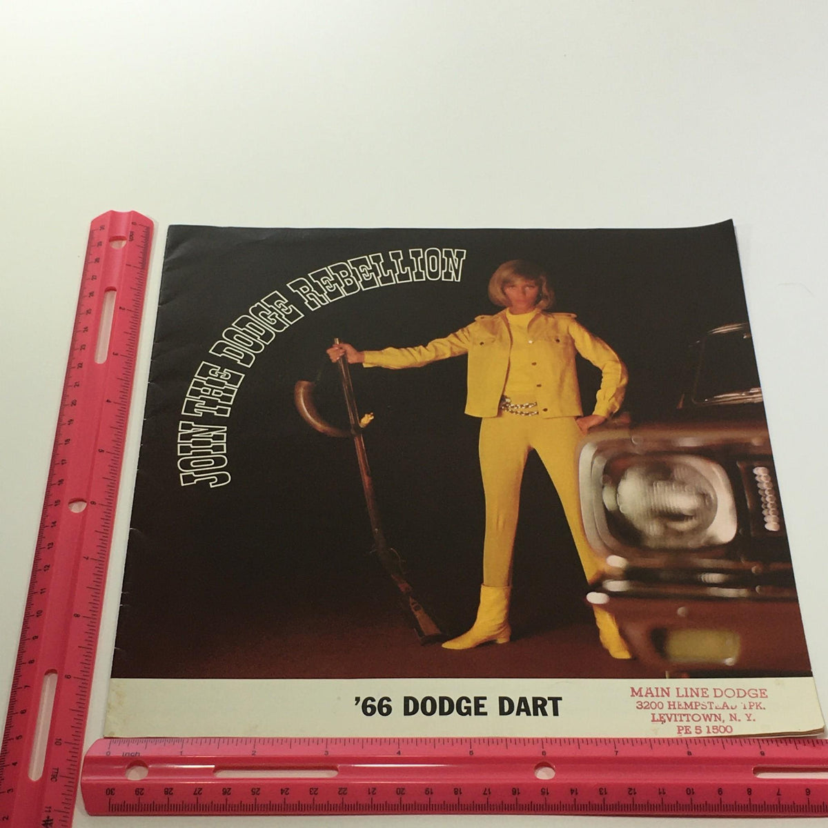 1966 Dodge Dart V-8 Engine 4-Speed Gearbox 2-Door Sedan Car Sale Brochure cover, inviting viewers to join the 'Dodge Rebellion' with a woman dressed in yellow posing confidently next to a vintage Dodge Dart.