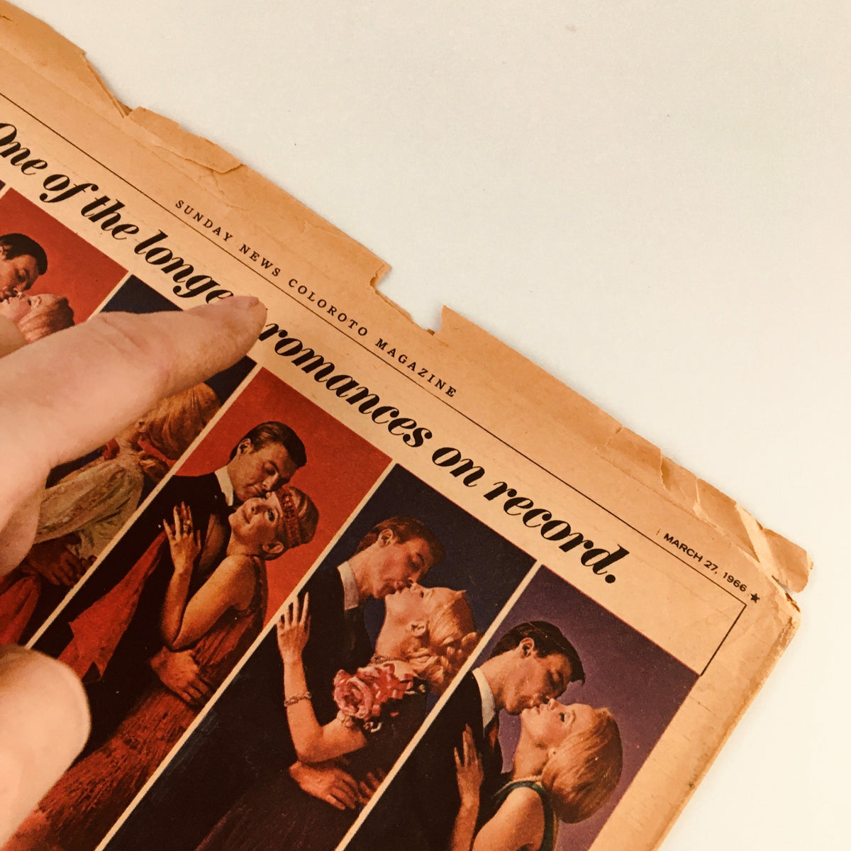 Close-up of the Sunday New York News Magazine from March 27, 1966, showcasing the title 'One of the longer romances on record.' The image highlights the magazine's vintage design and condition, featuring a pointed finger indicating the text on the cover.