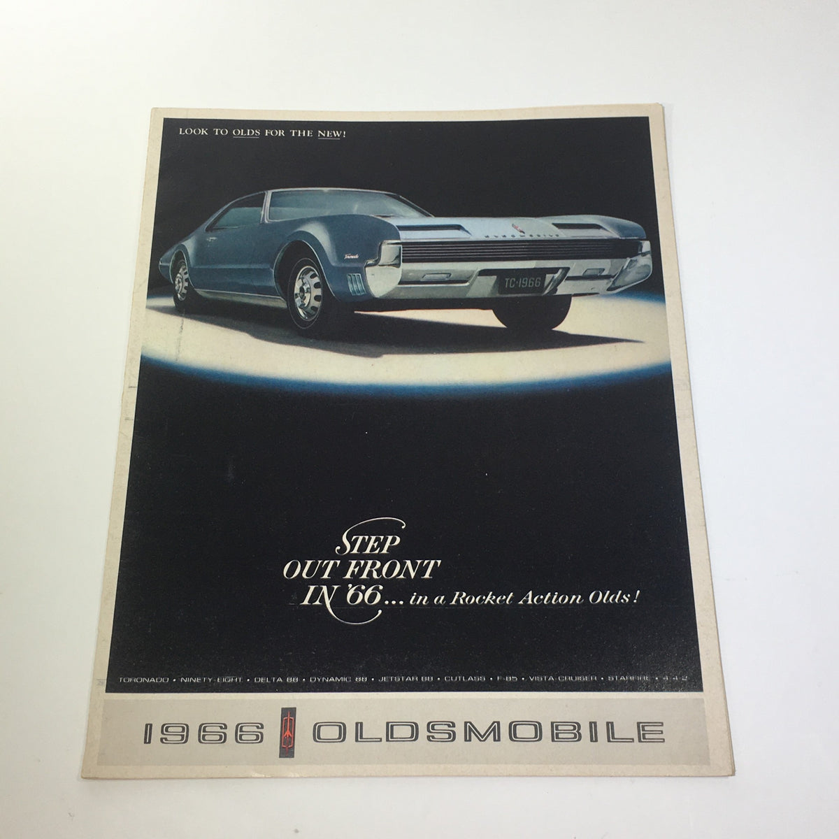 Front cover of the 1966 Oldsmobile Step Out Front Super Rocket V8 Engine 4-4-2 Car Catalog Brochure featuring a classic car design.