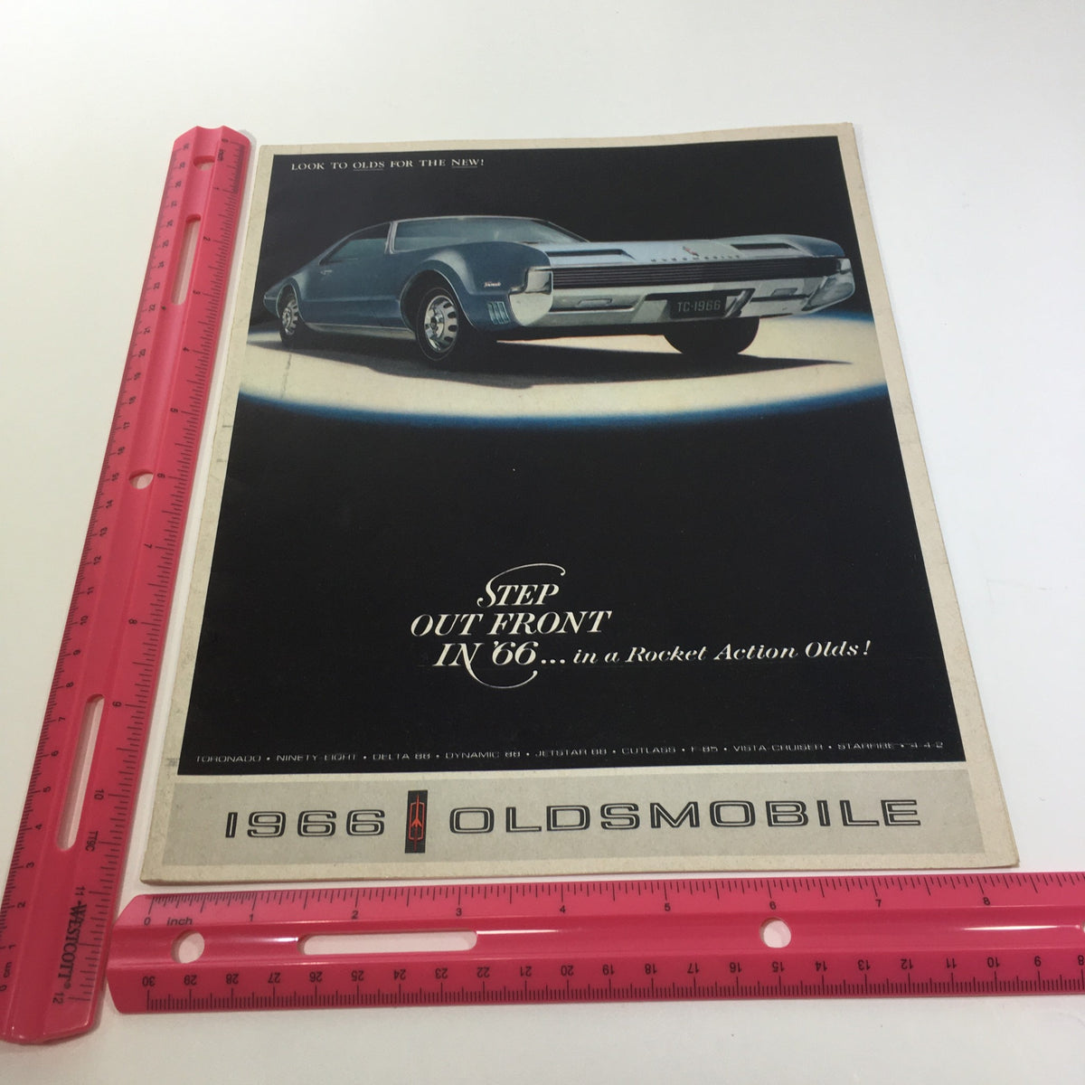 Cover of the 1966 Oldsmobile Step Out Front Super Rocket V8 Engine 4-4-2 Car Catalog Brochure featuring a vintage car design.