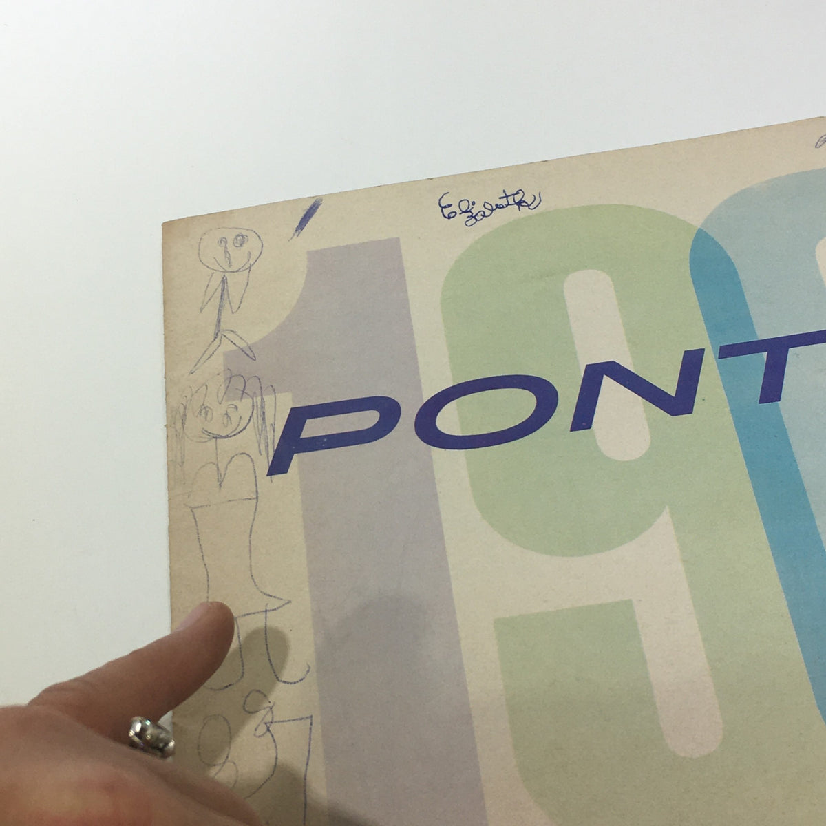 Close-up of the 1961 Pontiac Catalina Sport car catalog showing handwritten notes and designs on the cover, reflecting its vintage character.