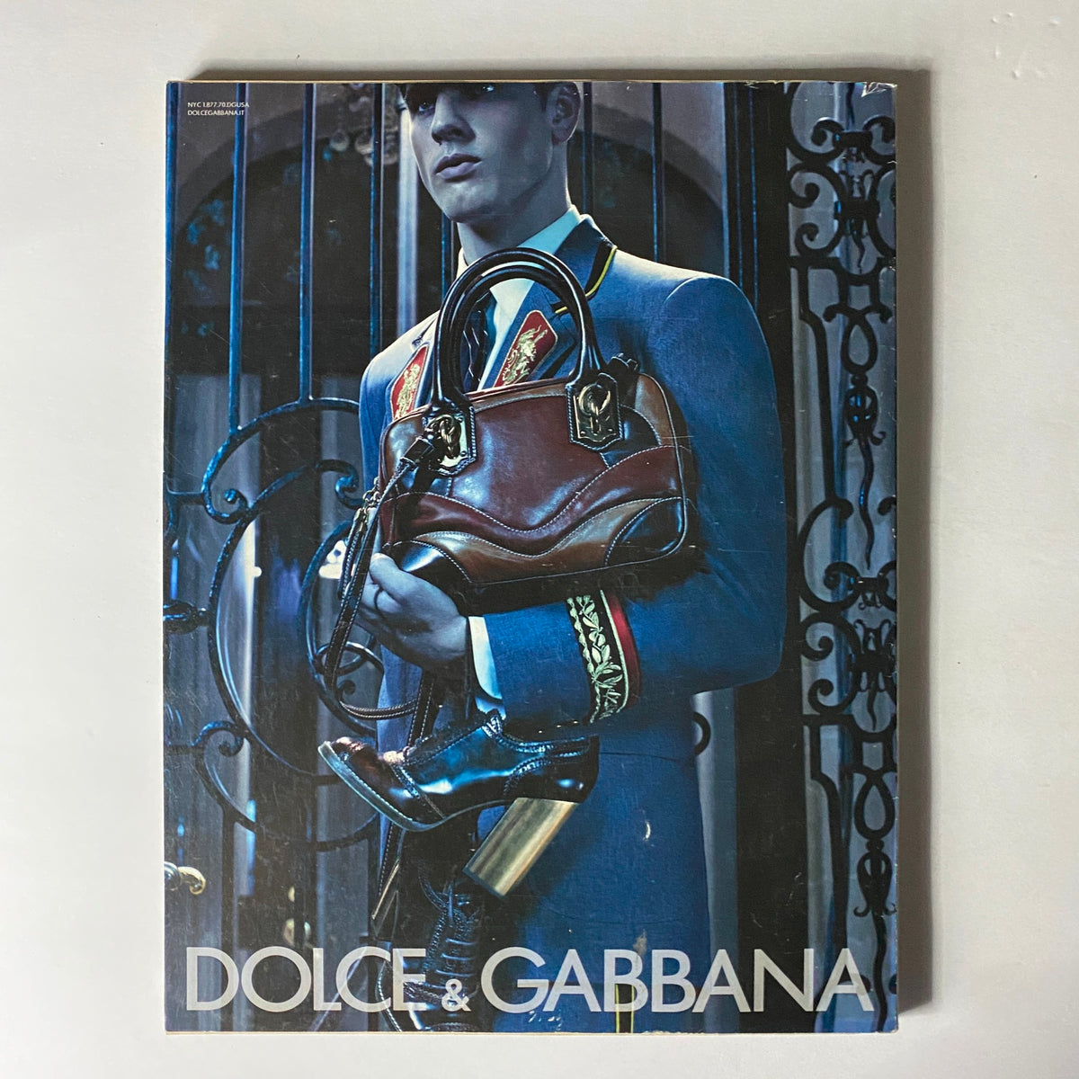 W Magazine August 2008 includes a striking advertisement for Dolce & Gabbana, featuring a model in a tailored suit holding elegant accessories, exemplifying luxury fashion trends of the time.