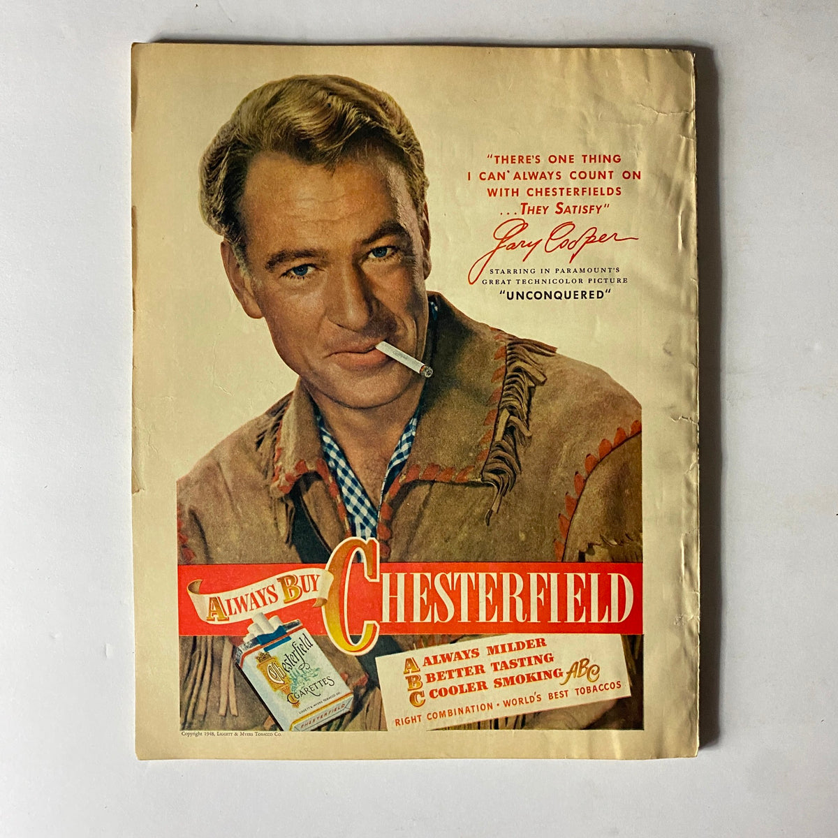 Cover of Sport Magazine January 1948 featuring a vintage advertisement for Chesterfield cigarettes with Gary Cooper. The illustration showcases Cooper in a western-style outfit, promoting the brand in a nostalgic, iconic display.