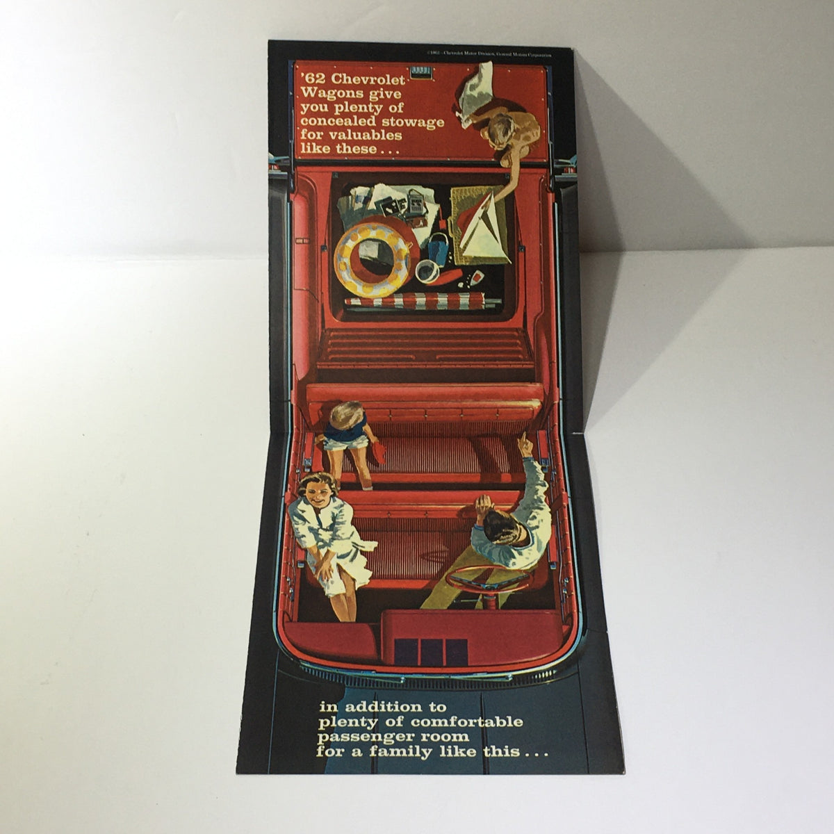 Inside image of the 1962 Chevrolet Wagons Impala 6-Passenger Wagon Greenbrier De Luxe Sports Catalog showing concealed stowage space with family-oriented illustrations of passengers and items being stored.