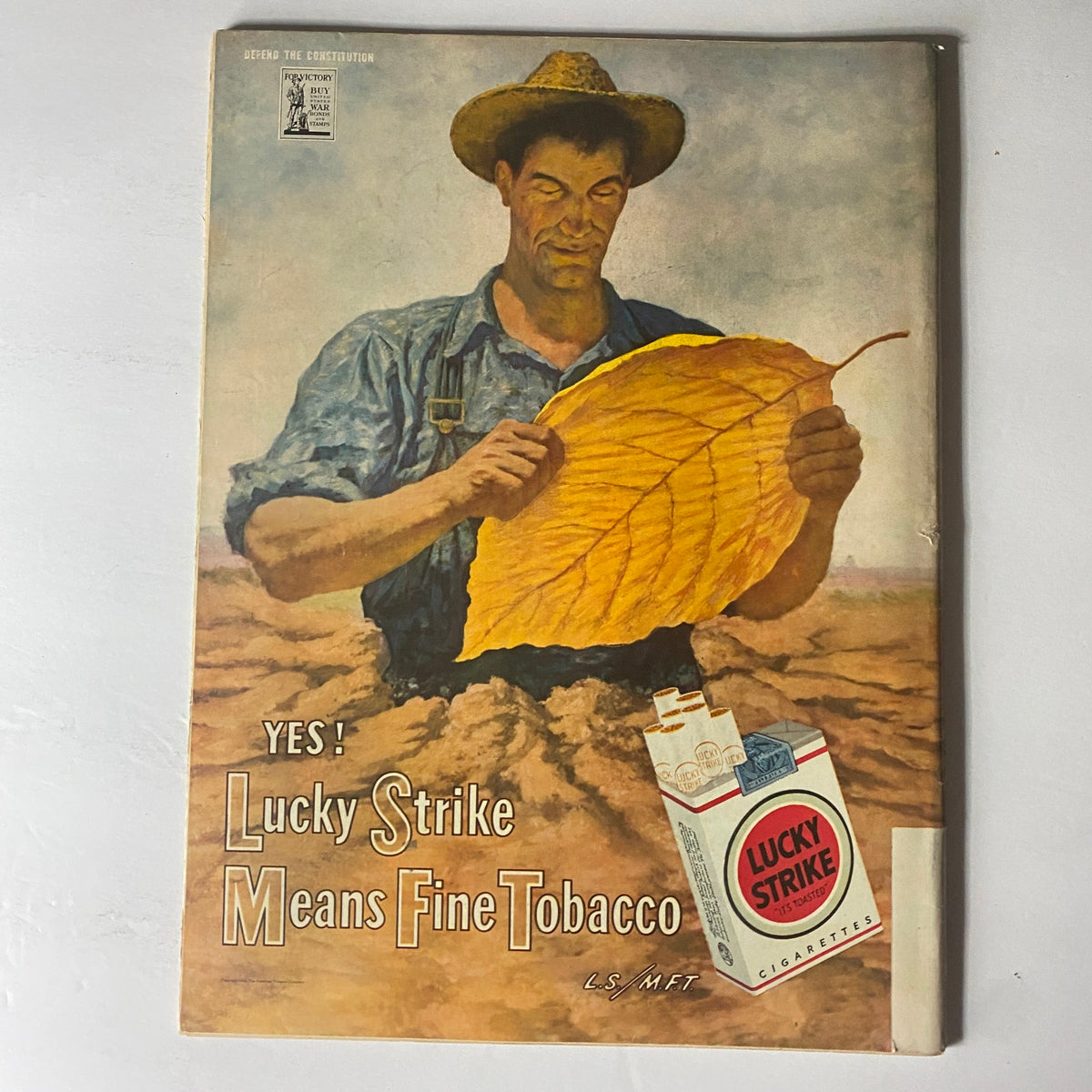 Vintage advertisement illustration from Life Magazine June 19, 1944 promoting Lucky Strike cigarettes with a farmer examining a large tobacco leaf.