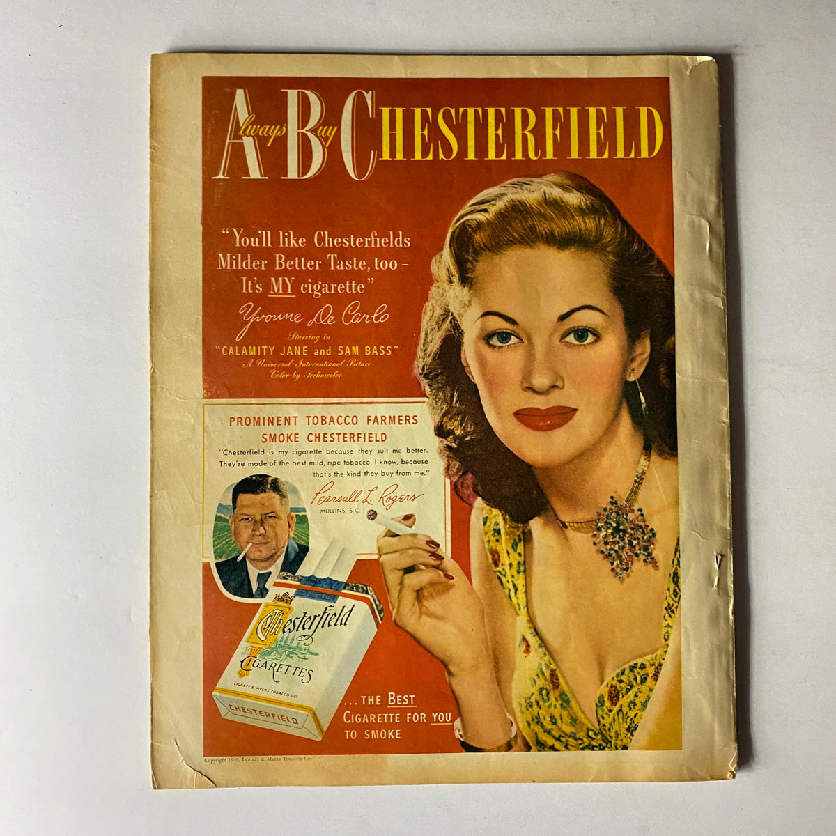 Vintage advertisement page from the 1949 magazine, featuring an advertisement for Chesterfield cigarettes and highlighting Yvonne De Carlo.