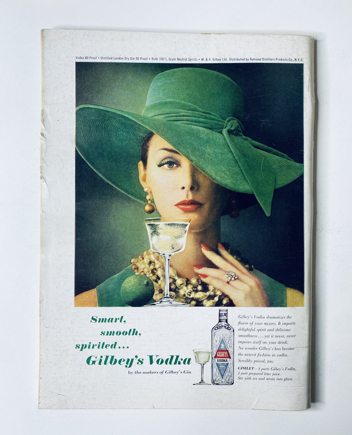 Back cover of The New Yorker Magazine October 17, 1964 showcasing an advertisement for Gilbey's Vodka, featuring a woman in a green hat and cocktail, emphasizing the product's smoothness and spirit.