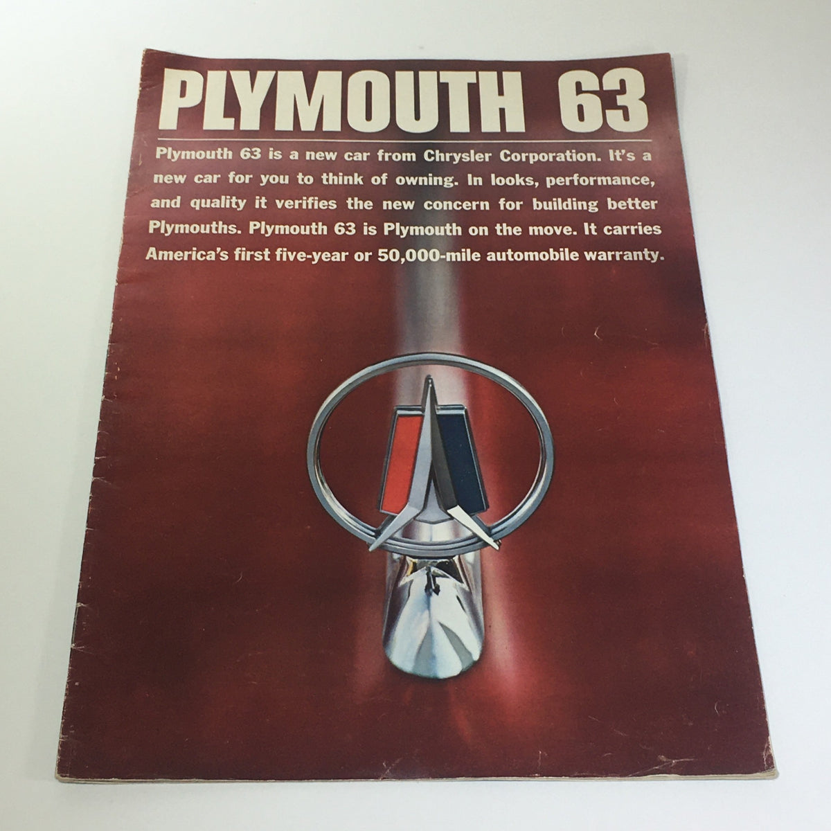 Cover of the 1963 Plymouth by Chrysler Corp. brochure showcasing the iconic logo and promotional text emphasizing the vehicle's affordability and warranty.