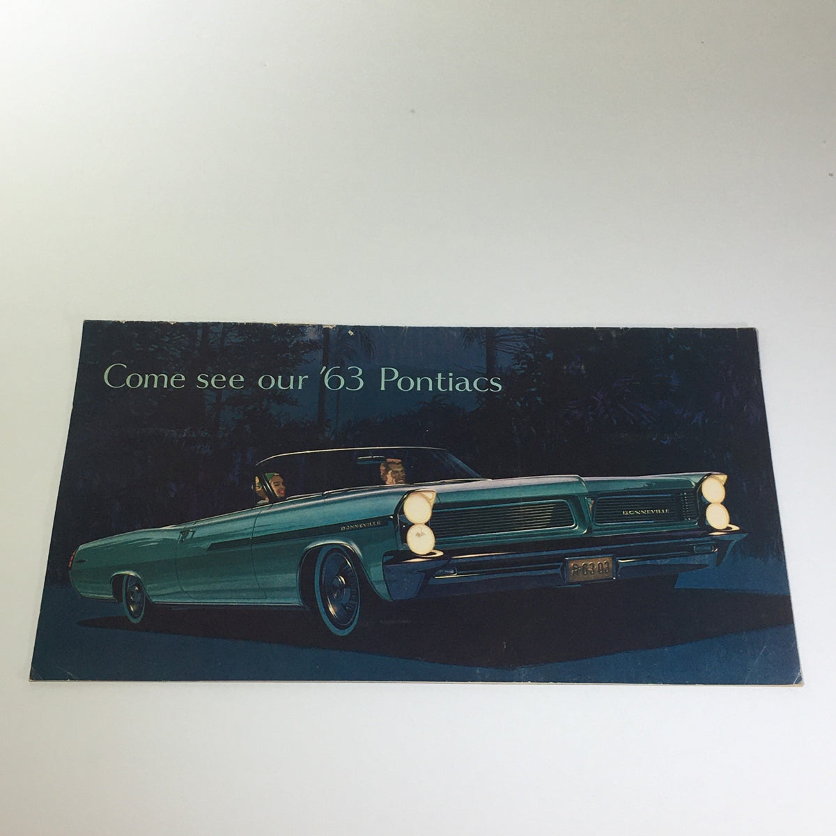 Front cover of the 1963 Pontiacs' The Bonnevilles Convertible 2-Door Sedan Car Catalog Brochure featuring a classic automobile in a vibrant color.