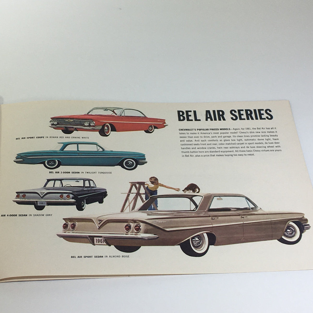 Interior view of the Chevrolet for 1961 Bel Air Series Sport Coupe 4-Door Sedan Car Catalog Brochure showcasing different models and colors in a vintage illustration.