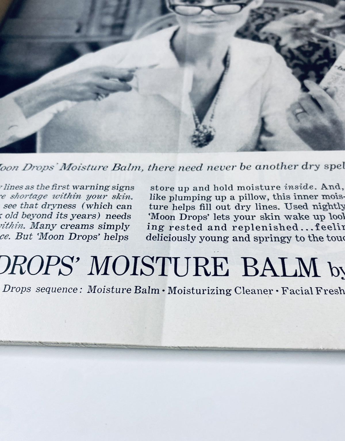 Close-up of an advertisement for 'Moon Drops' Moisture Balm featuring a woman demonstrating skincare tips. The New Yorker Magazine April 11, 1964 Arthur Getz City Construction Crane Cover.