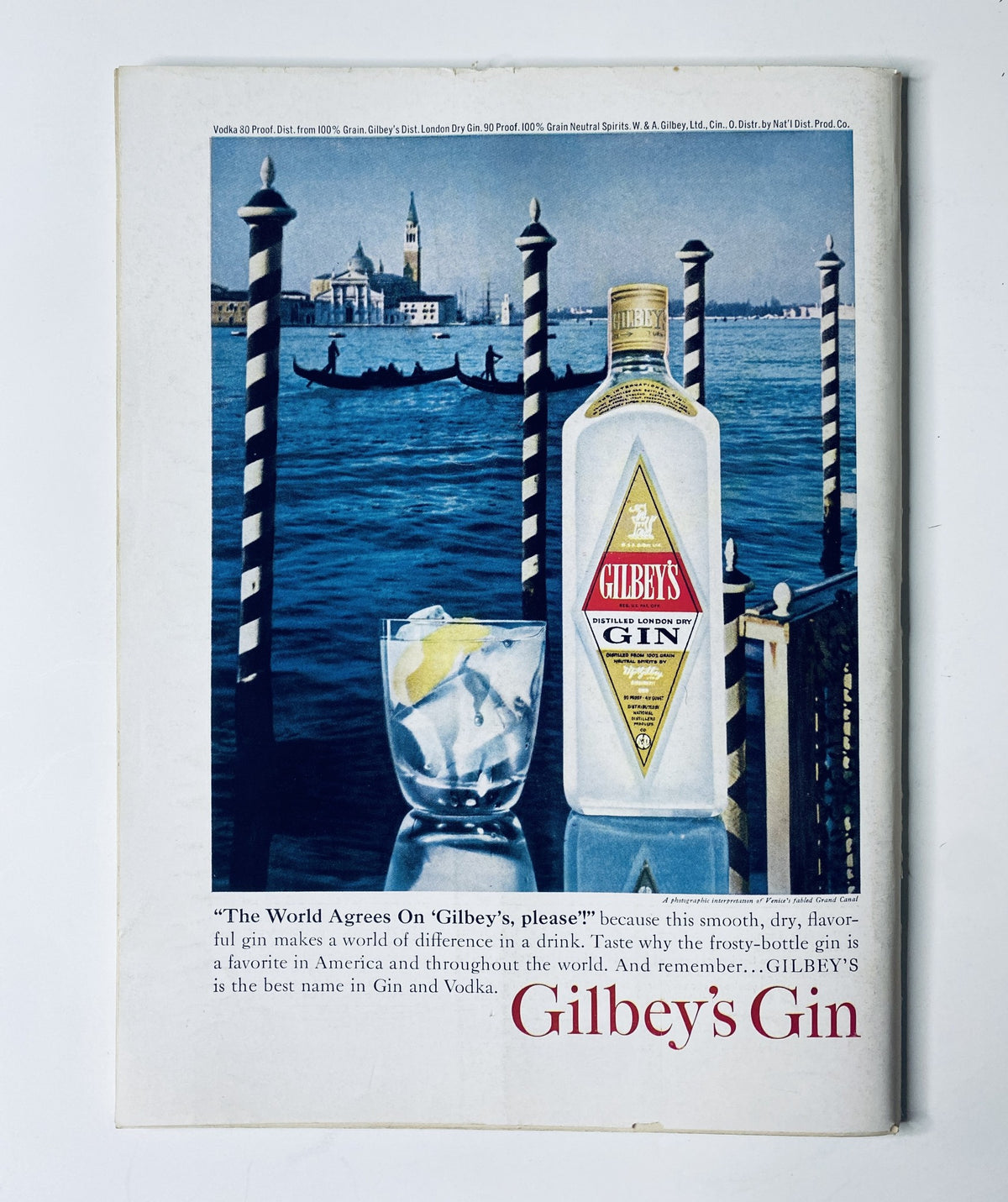 Vintage advertisement featuring Gilbey's Gin bottle in front of a scenic waterfront view, illustrating the tagline 'The World Agrees On Gilbey's please' and promoting its smooth flavor, relevant to The New Yorker Magazine April 4, 1964 Peter Arno Dancing Man Cover.