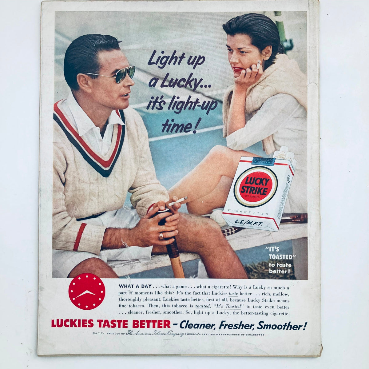 Lucky Strike cigarette advertisement featuring a stylish couple, promoting the slogan 'Light up a Lucky... it's light-up time!' from Look Magazine May 17 1955.