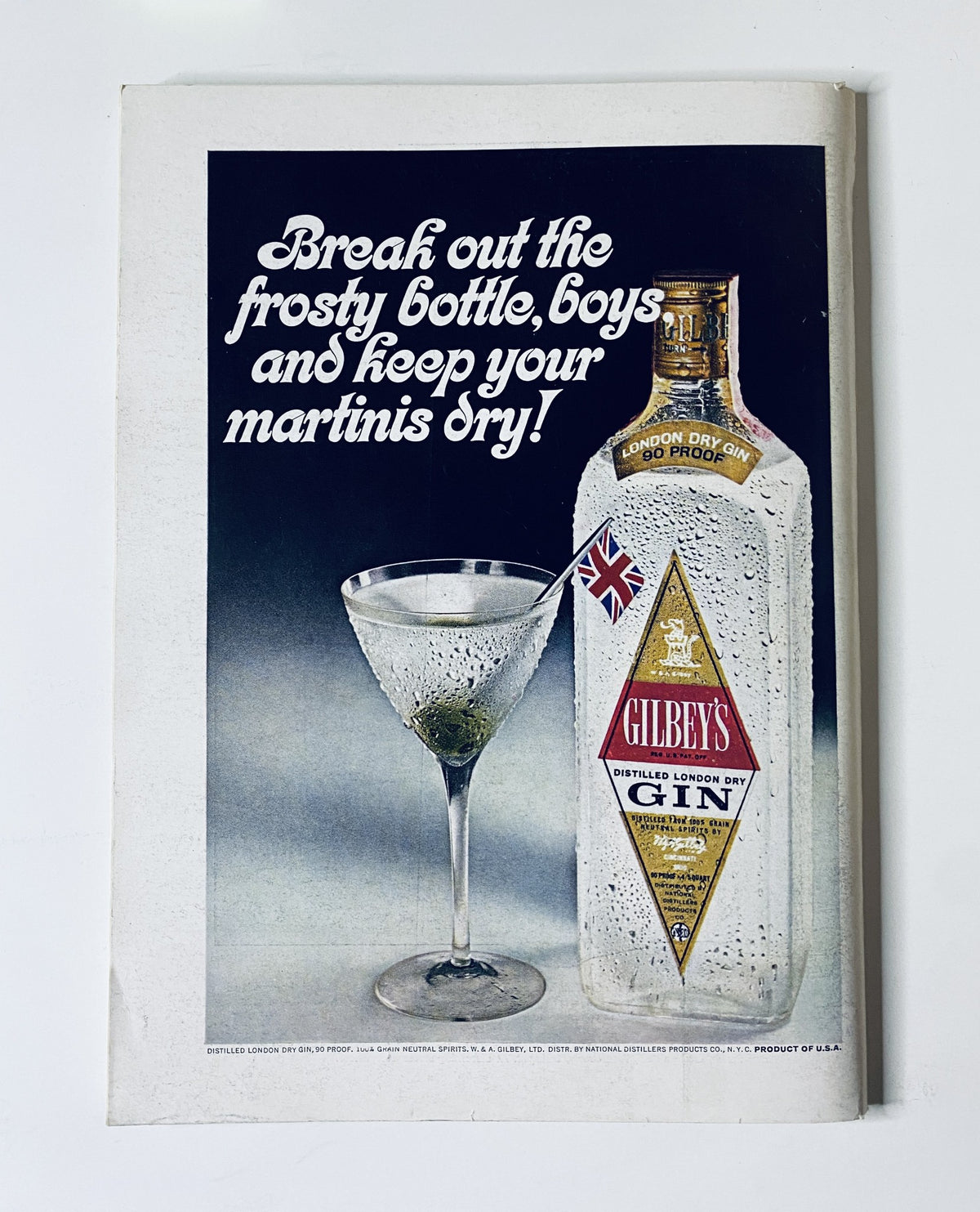 Cover illustration for The New Yorker Magazine from October 14, 1967, featuring a vintage advertisement for Gilbey's Gin, promoting the drink with the tagline 'Break out the frosty bottle, boys and keep your martinis dry!'. The image showcases a classic martini alongside the iconic bottle.