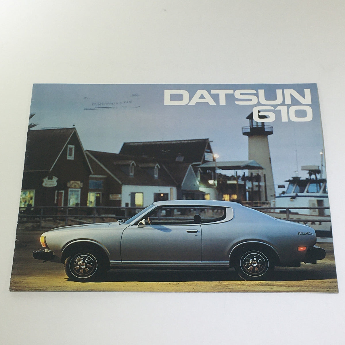 Vintage 1970 Datsun 610 Hardtop Sedan Wagon Series Patch-#11772 car brochure featuring a classic Datsun model parked near a coastal setting.
