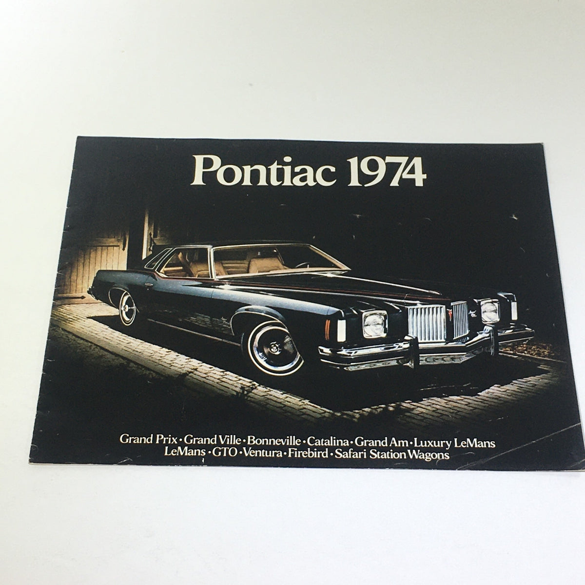 1974 Pontiac Grand Ville 4-Door Hardtop V-8 Sedan Car Auto Catalog Brochure cover featuring a sleek black Pontiac model, highlighting vintage automotive design.