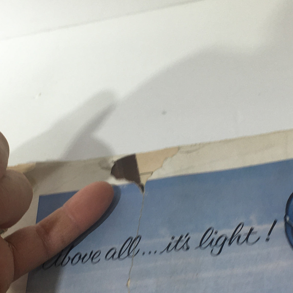 Detail of the back cover of The New Yorker: October 4, 1958 highlighting a tear and the text 'Above all...it's light!' from a Long John Scotch advertisement.