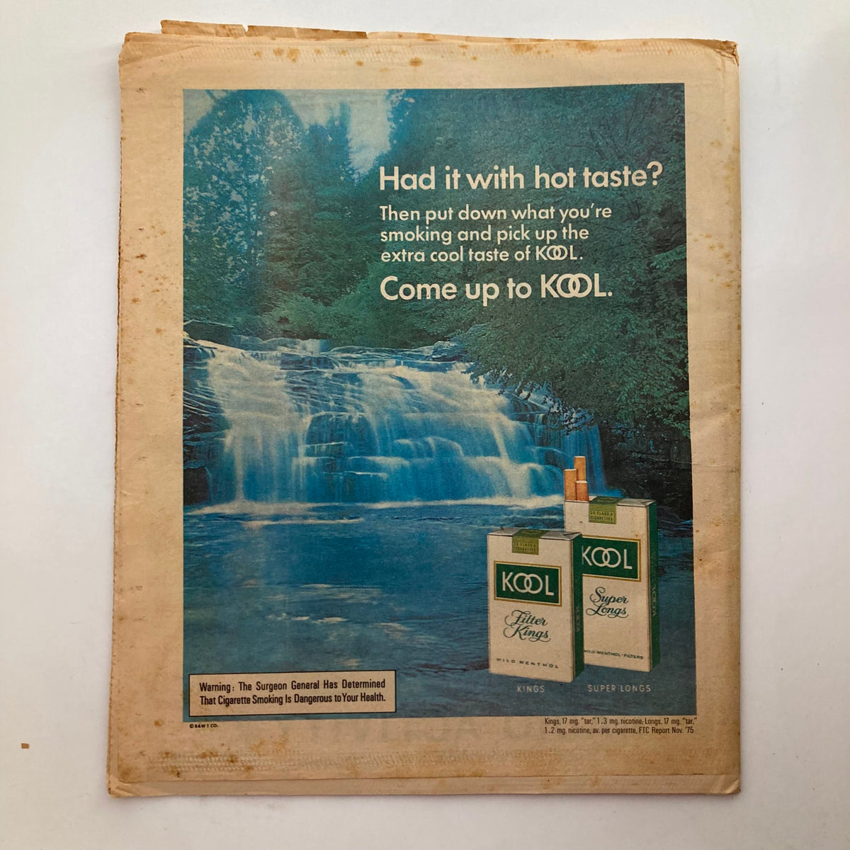 Vintage advertisement for KOOL cigarettes featuring a tranquil waterfall scene, promoting the extra cool taste of KOOL. Featured in Rolling Stone Magazine January 1, 1976 Issue 203 with Jefferson Starship on the cover.