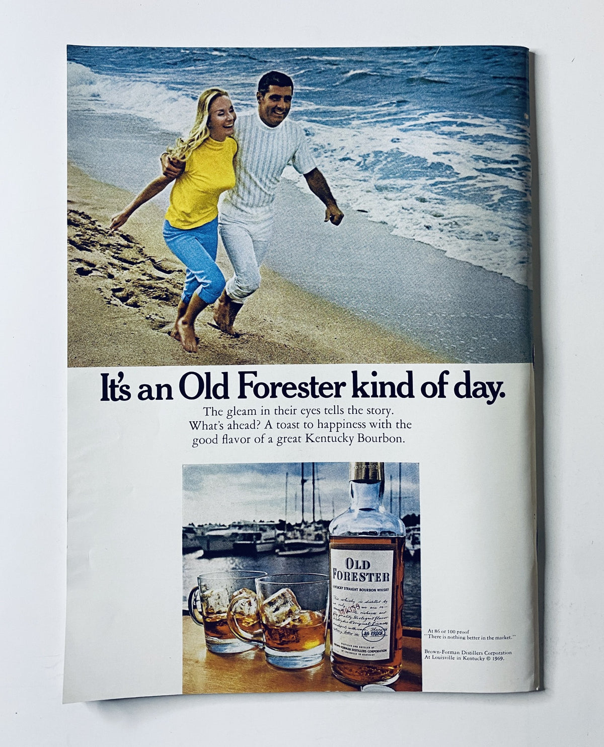 An advertisement from The New Yorker Magazine June 28, 1969 for Old Forester Bourbon, depicting a couple on the beach. The caption reads, 'It's an Old Forester kind of day,' promoting the enjoyment of Kentucky Bourbon.