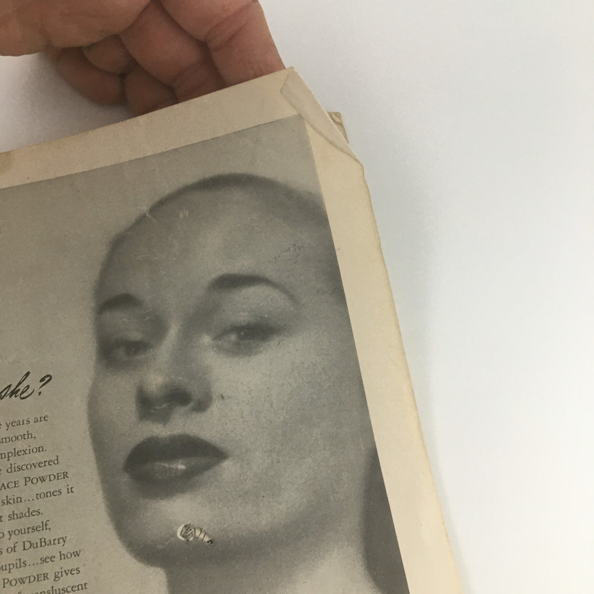 Close-up view of a vintage advertisement in a 1947 Playbill from the Lyceum Theatre's production of 'Born Yesterday' featuring a woman modeling face powder.