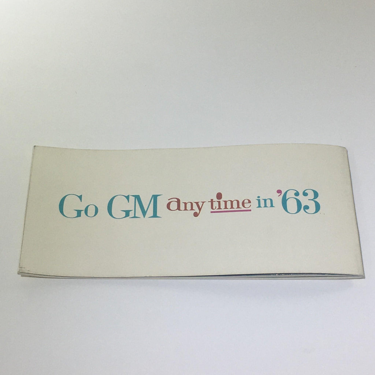 Cover page of the Vintage Go GM Any Time in the year 1963 Chevrolet-Pontiac-Buick Car Catalog, featuring the title in an artistic font.