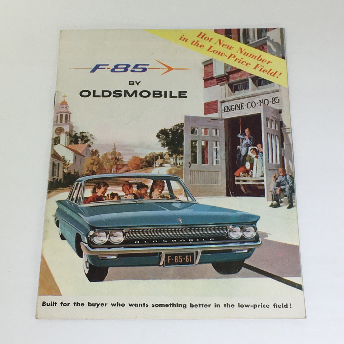 Vintage 1961 All New F-85 Oldsmobile 4-Door Hardtop Sedan Car Catalog Brochure cover featuring a stylish blue Oldsmobile parked in a charming scene.