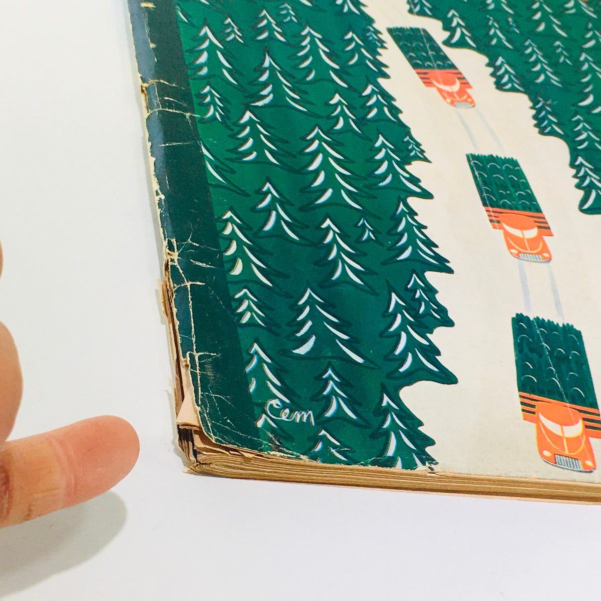 Close-up view of the worn edge of The New Yorker magazine from December 3, 1960, showcasing intricate green tree illustrations and vintage design details.
