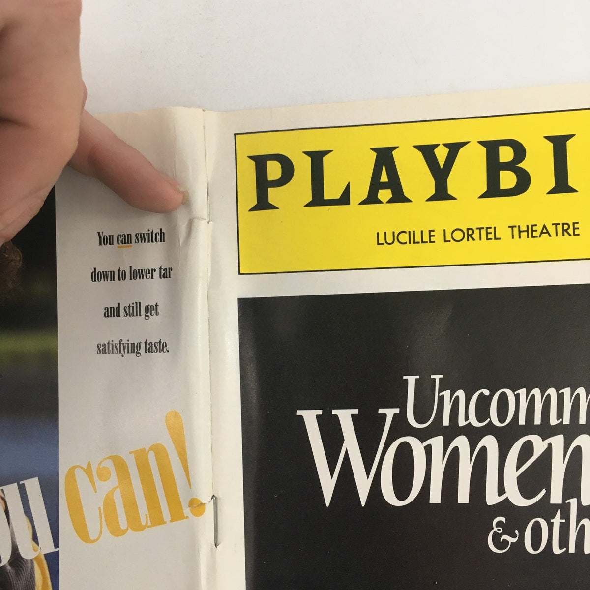 Close-up of the binding of the 1994 Playbill from Lucille Lortel Theatre for 'Uncommon Women & Others', highlighting wear with a statement about taste.