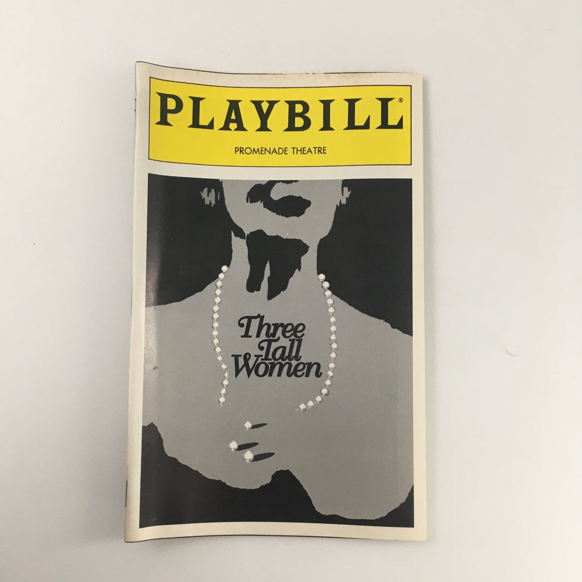 1995 Playbill for 'Three Tall Women' performed at The Promenade Theatre, showcasing a minimalist cover design with a silhouette and pearls, representing key themes of the play.